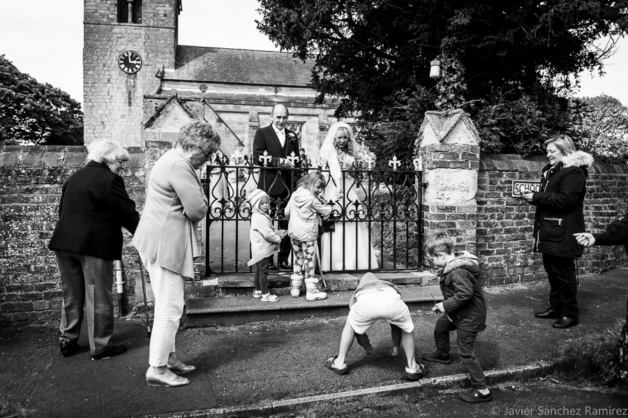 Children block the gate of the church waiting for some coins from the bride and groom