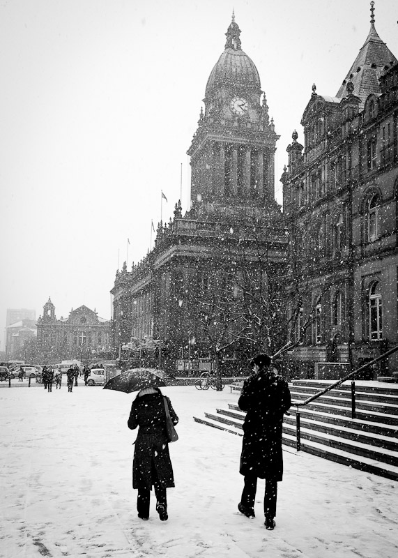 people walking in front city council of leeds in the snow