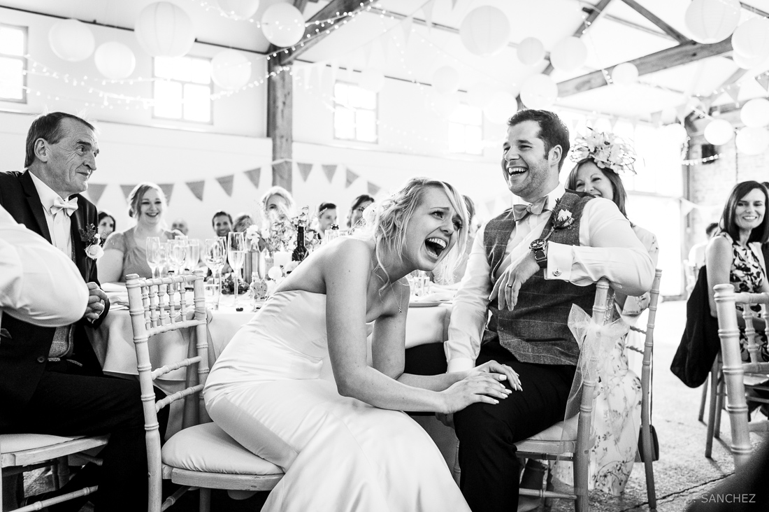 Bride laughing at the wedding speeches